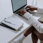 A woman working on a laptop in a modern home office setting, capturing a cozy and productive atmosphere.
